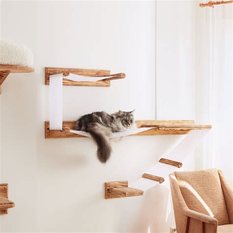 a cat laying on top of a wooden shelf next to a chair in a living room