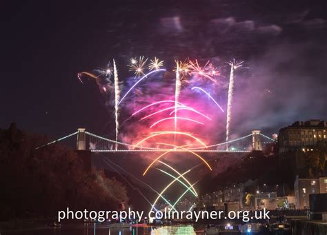 fireworks are lit up in the sky above a bridge