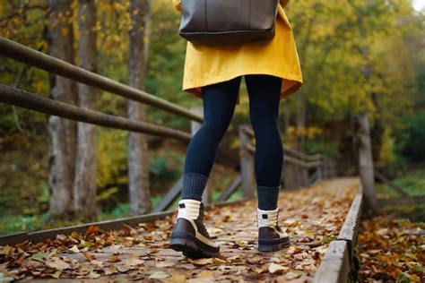 Premium Photo | Women's feet in boots go along a wooden walking path in ...