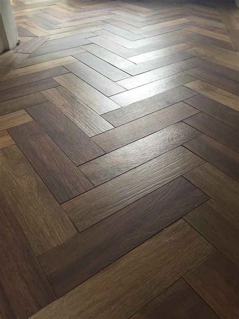 Dark wood effect porcelain floor tiles laid in a herringbone pattern # ...