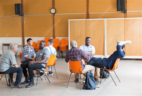 Men talking in group therapy in community centre - Stock Image - F023/9168 - Science Photo Library