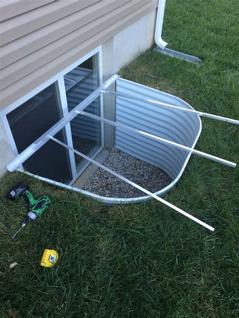 a small boat sitting in the grass next to a house with tools on top of it