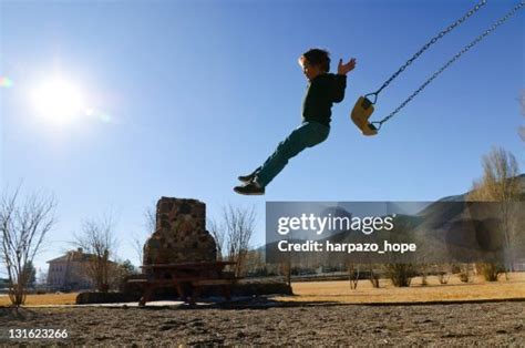 Boy Jumping Off Swing High-Res Stock Photo - Getty Images