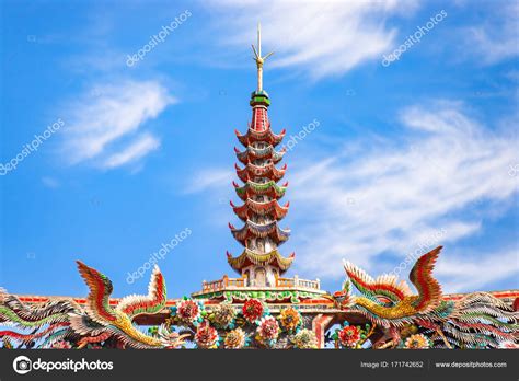 Chedi and Beautiful Phoenix flying on the decorative tile roof in Chinese temples. Colorful roof ...