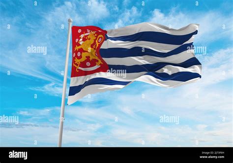 official flag of Blue-White Striped , Finland at cloudy sky background ...