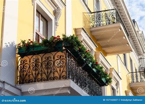 Black Ornate Wrought Iron Balcony Decorated with Flowers. Boxes with Red Geraniums. Bottom Side ...