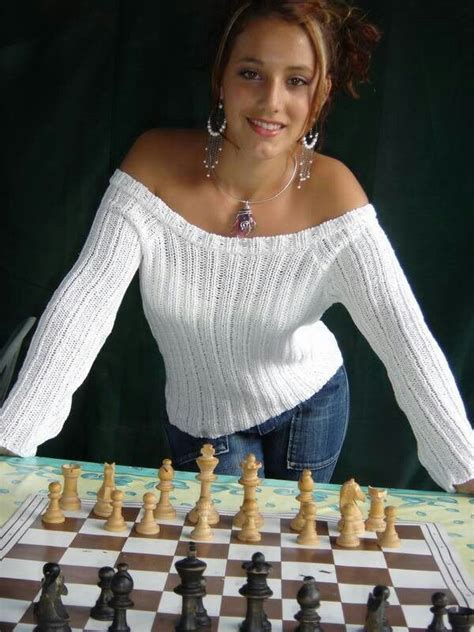 a woman is posing next to a chess board