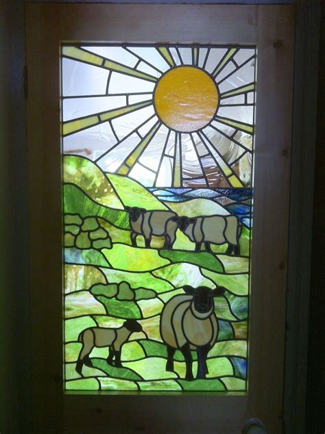 5. Finished stained glass window with three sheep and a lamb and the sea in the distance ...