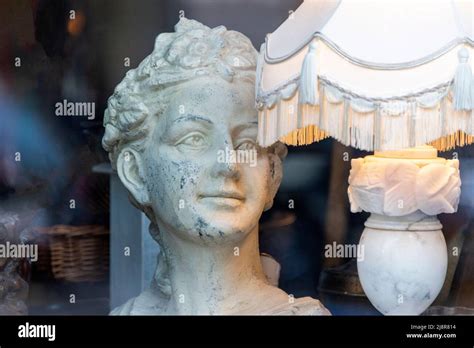 Antique woman bust sculpture near vintage lamp in shop window Stock Photo - Alamy