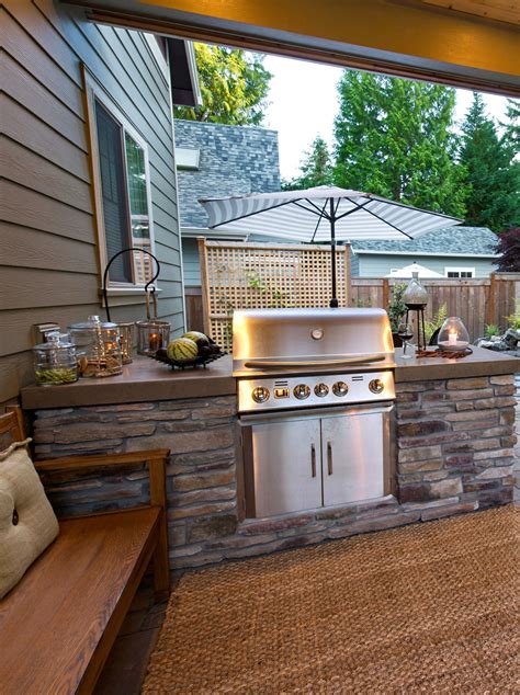 an outdoor kitchen with grill and seating area