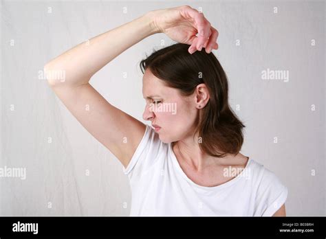 Young woman smells armpit with disgust and smells strong under arm ...