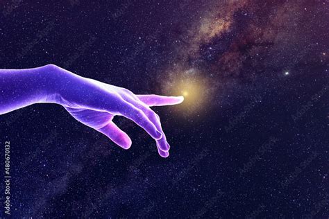 Hand of God universe creation concept. A sparkling star covered purple and pink lit hand points ...