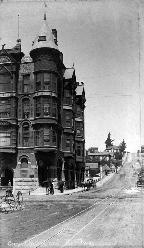 an old black and white photo of a large building on the corner of a street