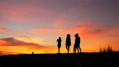 Couple Walks Into Sun Up Hill And Then Stops To Take In Romantic Scenery, Put Arms Around Each ...