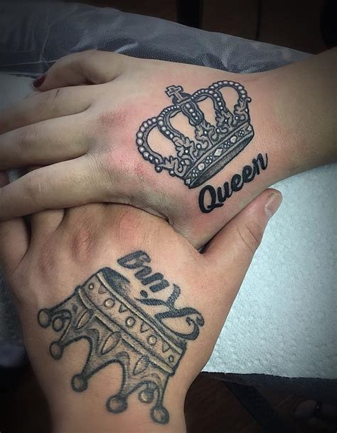 A stylized pair of king and queen crowns tattoos on hand. - Blurmark