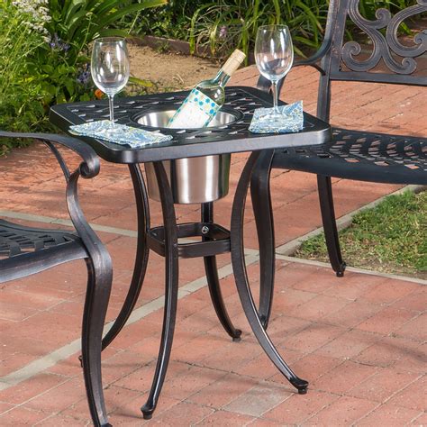 an outdoor table with two wine glasses on it