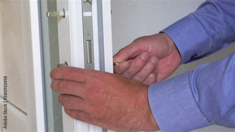 installing a lock on the door,assembling of a door cylinder in a white plastic door Stock ビデオ ...