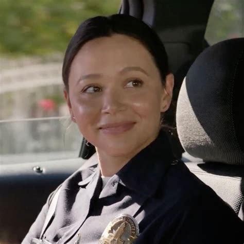 a woman police officer sitting in the back seat of a car smiling at the ...