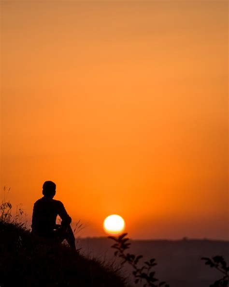 Silhouette of Sitting Person at Sunset · Free Stock Photo