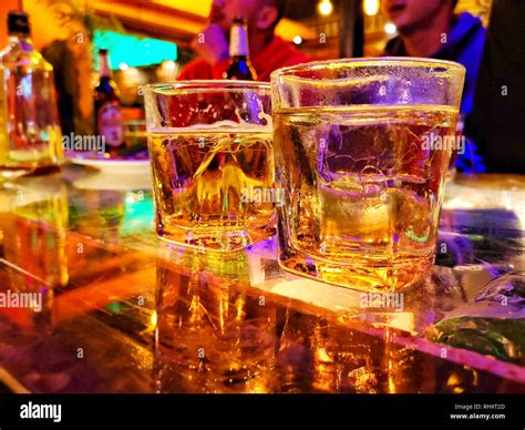 Whiskey drinks on the table in bar, image with color and noise filter effect Stock Photo - Alamy