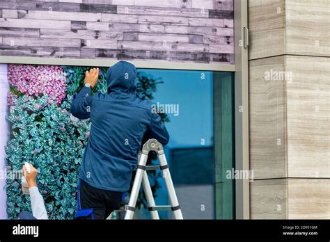 Workers installing window film outdoor. Window foil installation Stock Photo - Alamy