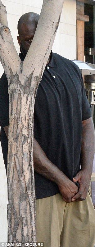 Shaquille O'Neal goofs around with the camera as he 'hides' his 7'1" frame | Daily Mail Online