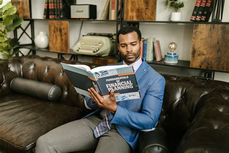 Man Sitting on Sofa While Reading a Book · Free Stock Photo