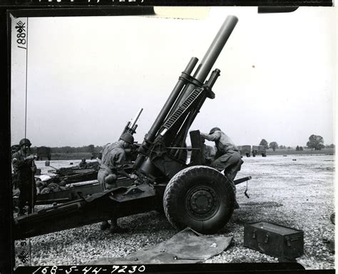 Cleaning and removing the breach block of a 155mm Howitzer after firing at Camp Atterbury ...