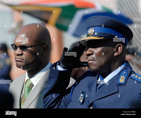 South Africa's Police Commissioner Bheki Cele salutes standing next ...