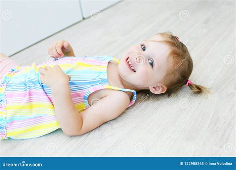 Cheerful Cute Little Girl Lying on the Floor in the Children`s Stock ...