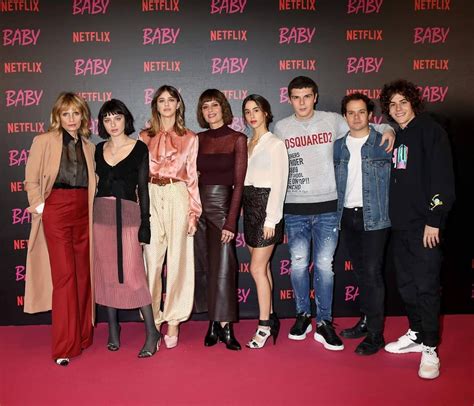 a group of people standing next to each other on a red carpet in front of a sign