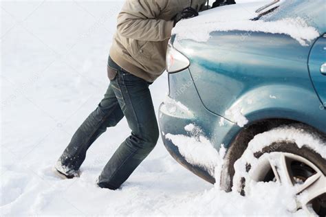 Closeup of man pushing car stuck in snow — Stock Photo © Syda_Productions #40108895