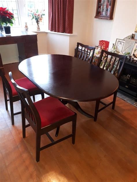 Dining table and 4 chairs for sale. Stag pedestal oval table extendable. Dark wood. Matching ...