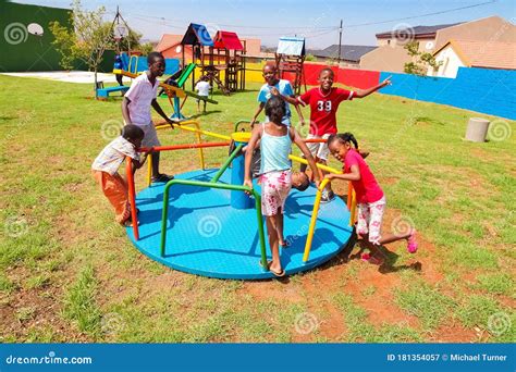 African Kids Playing Merry Go Round and Other Park Equipment at Local Public Playground ...