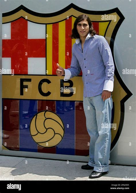 Martin Caceres of Uruguay poses next to an emblem of Barcelona soccer club after signing with ...