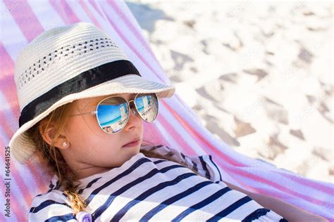 Portrait of little adorable girl lying on beach lounger Stock Photo | Adobe Stock