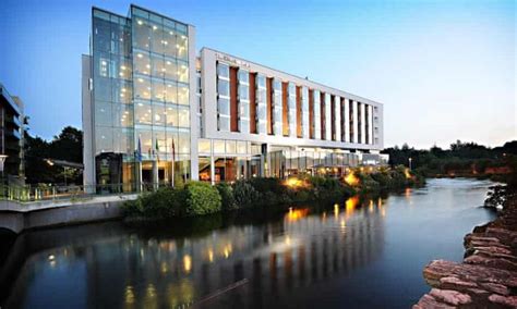 an office building next to a river at dusk