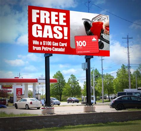 a gas station sign with the words free gas on it and cars parked in the lot