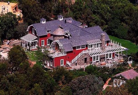 an aerial view of a red house surrounded by trees