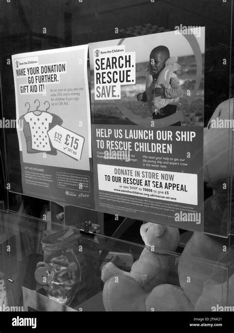 Save the Children poster in charity shop window, rescue refugee boat children appeal Stock Photo ...