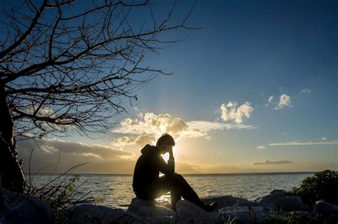 Premium Photo | Sad young man silhouette worried on the stone at sunset ...