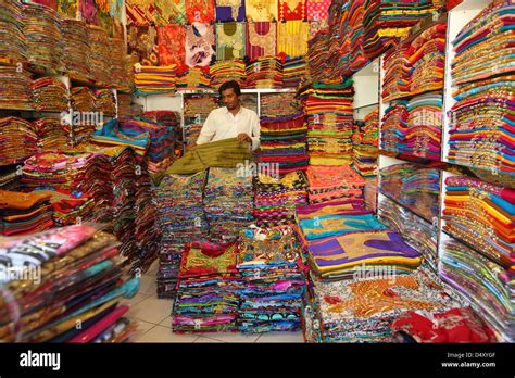 Man folding fabric in textile shop, Dubai, United Arab Emirates Stock Photo - Alamy