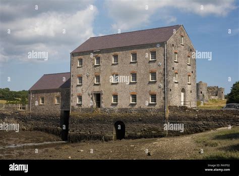 Carew Tidal Mill with Carew Castle in distance Stock Photo - Alamy