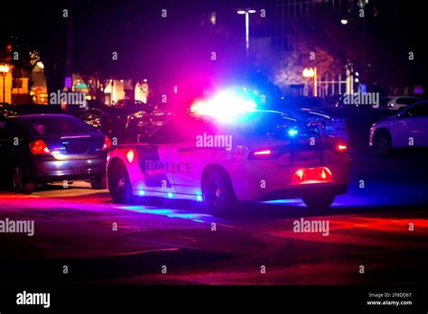 Police car with emergency lights flashing at night in city from the ...