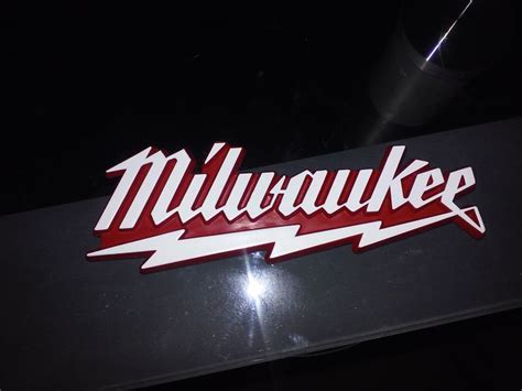 the milwaukee logo is shown in red and white on a black background with ...