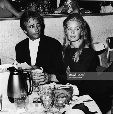 American film director John Derek and his wife, actor Linda Evans sit ...