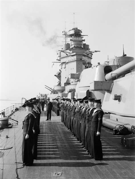 The crew of HMS Rodney parades for inspection on deck next to her 16 ...