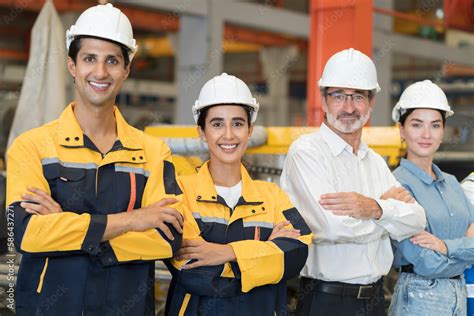 Group of male and female factory workers standing together with crossed ...