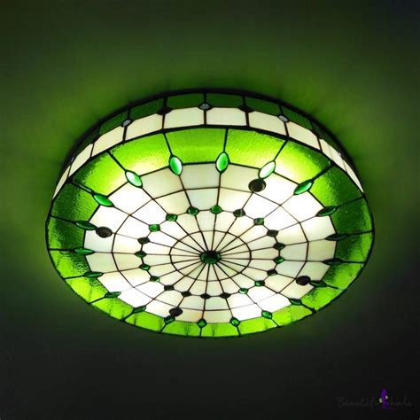 a green and white ceiling light in a dark room