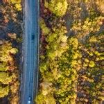 Aerial view of rural road in yellow and orange autumn forest in rural Finland. Stock Photo by ...